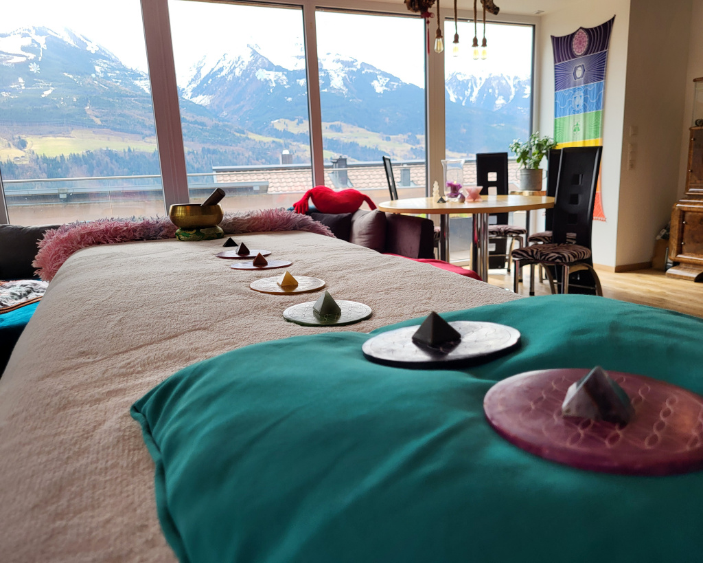 Entspannungsraum mit Liege, Deko-Elementen und Bergblick